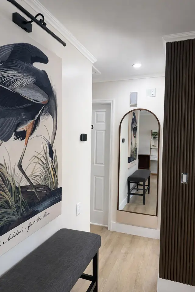 Hallway at Even Keel with a heron mural and an arched mirror