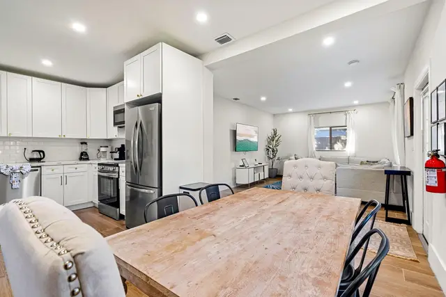 Open-plan dining area and kitchen at Light House, with a wooden table and the living room beyond