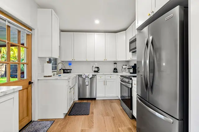 Kitchen at Light House with white cabinets, a stainless steel refrigerator, dishwasher and oven