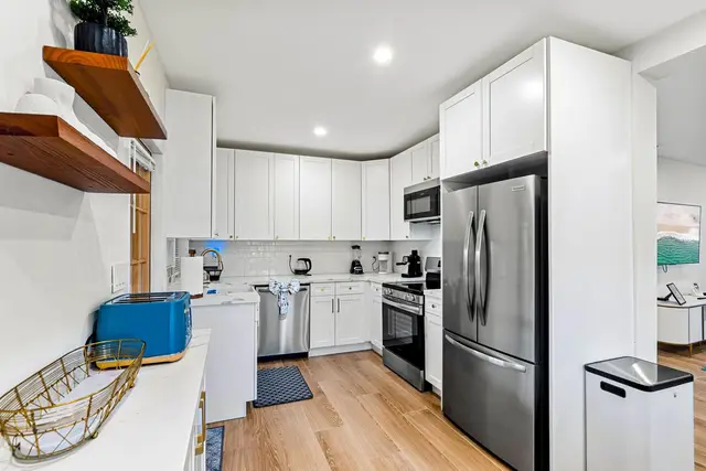 Kitchen at Light House with white cabinets and stainless steel appliances