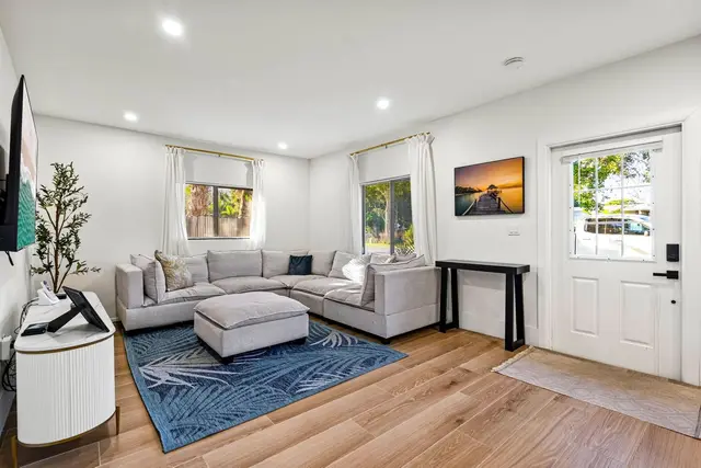 Living room at Light House with a grey sectional sofa, a patterned rug and a wall-mounted TV