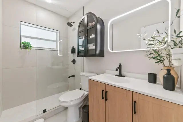 Bathroom at Lily Pad with a walk-in shower, a wooden vanity and black fixtures
