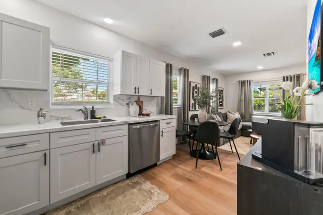 Kitchen at Lily Pad with white cabinets and a dishwasher, open to the dining area