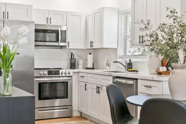 Kitchen at Lily Pad with white cabinets, a stainless steel stove and a microwave