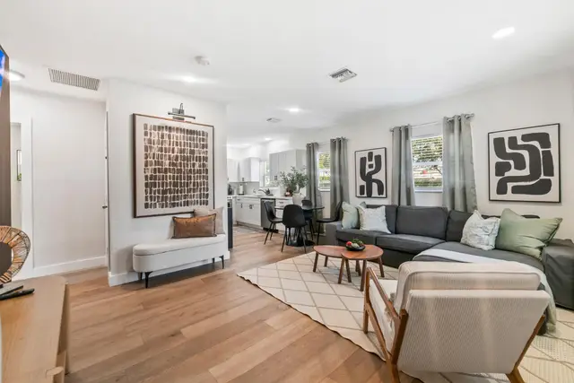 Open living area at Lily Pad with a grey sectional sofa, framed art and a patterned rug