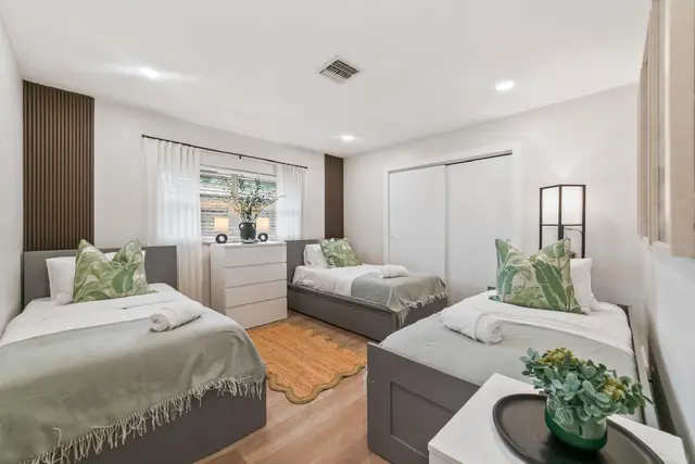 Bedroom at Lily Pad with twin beds, green throws and a dresser