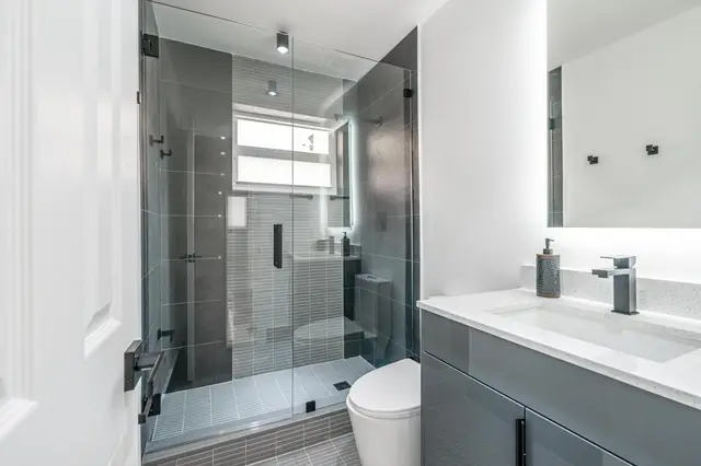 Bathroom at The Gulch with a glass walk-in shower, grey vanity and toilet